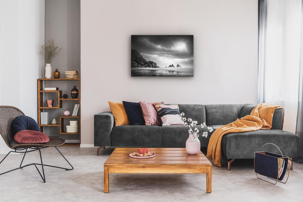 New Zealand landscape photo canvas wall art in neutral lounge setting with a grey couch, coffee tables and books